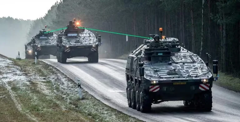 Military vehicles on a road with drawn connection lines illustrating optical communication.
